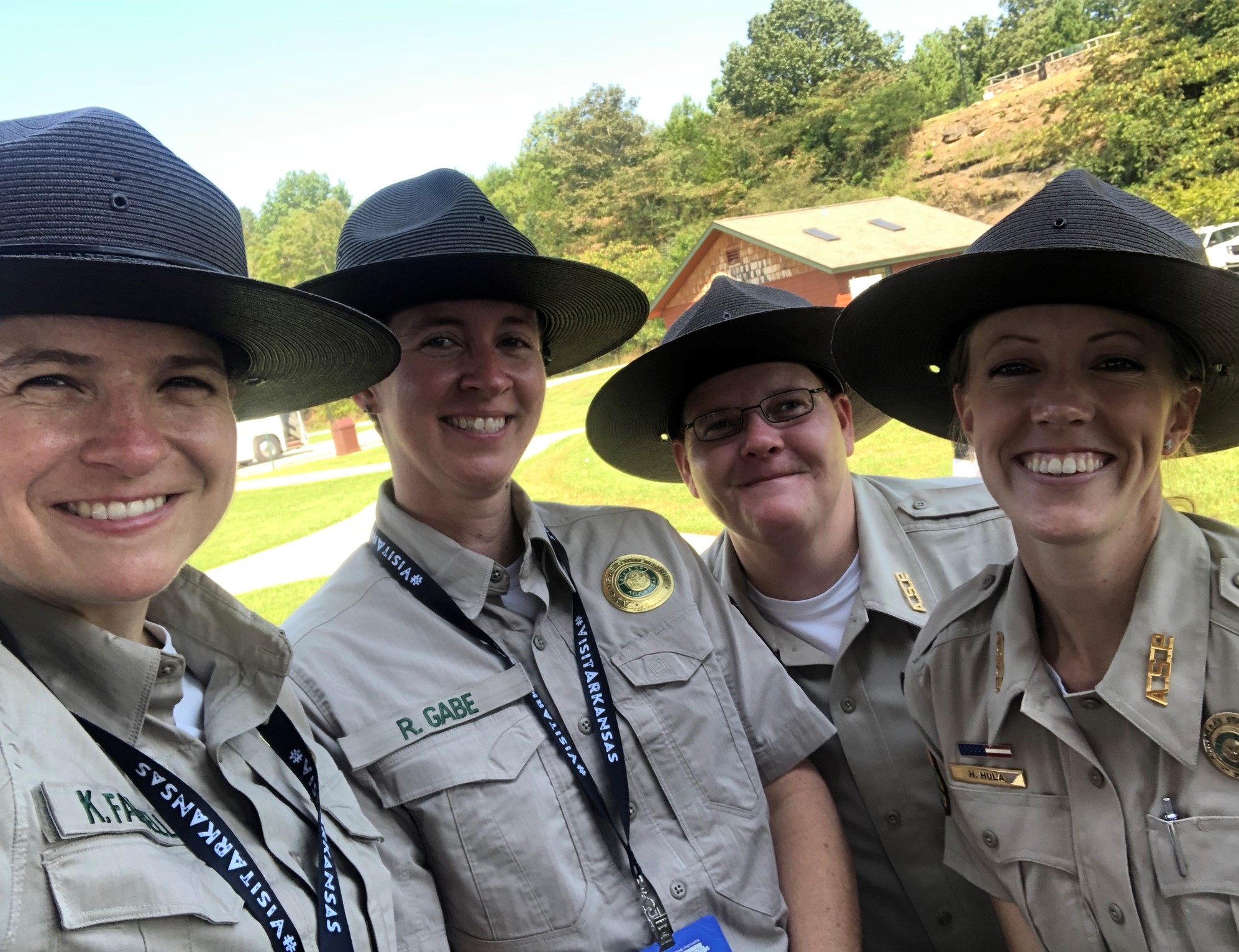 Four park interpreters in uniform, all smiling 