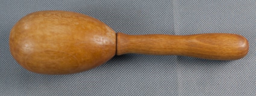 wooden darning egg on a handle against a gray background 