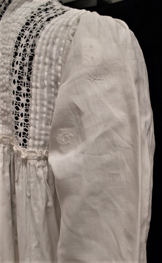 closeup of several patches on a white nightgown sleeve 