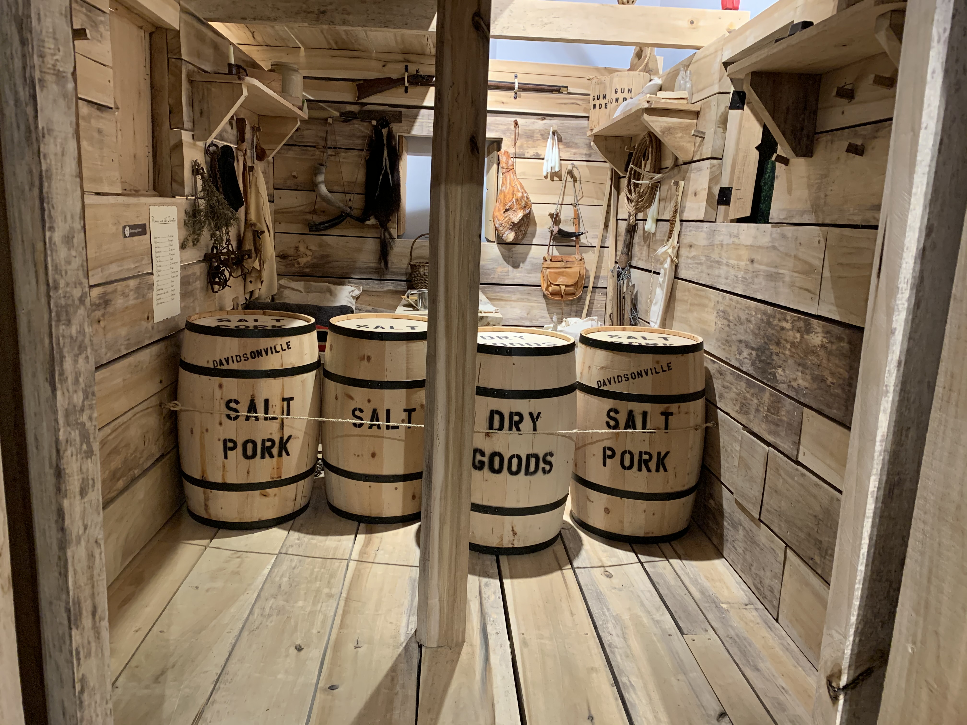 Inside view of the life-sized flatboat found at Davidsonville Historic State Park, pictured with things that would be found in a flatboat such as barrels of pork and dry goods. 