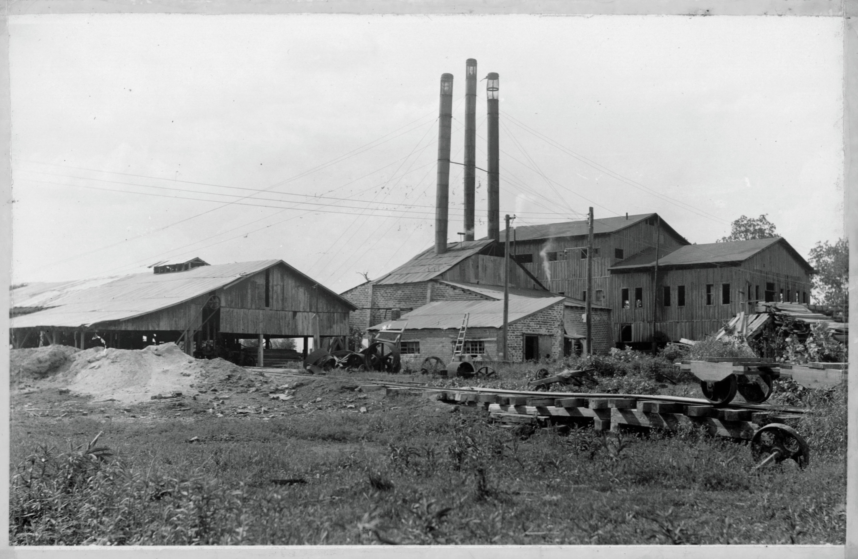 Black and white photograph of the buildings that housed the sawmill that was located on what is now Parkin Archeological State Park. 