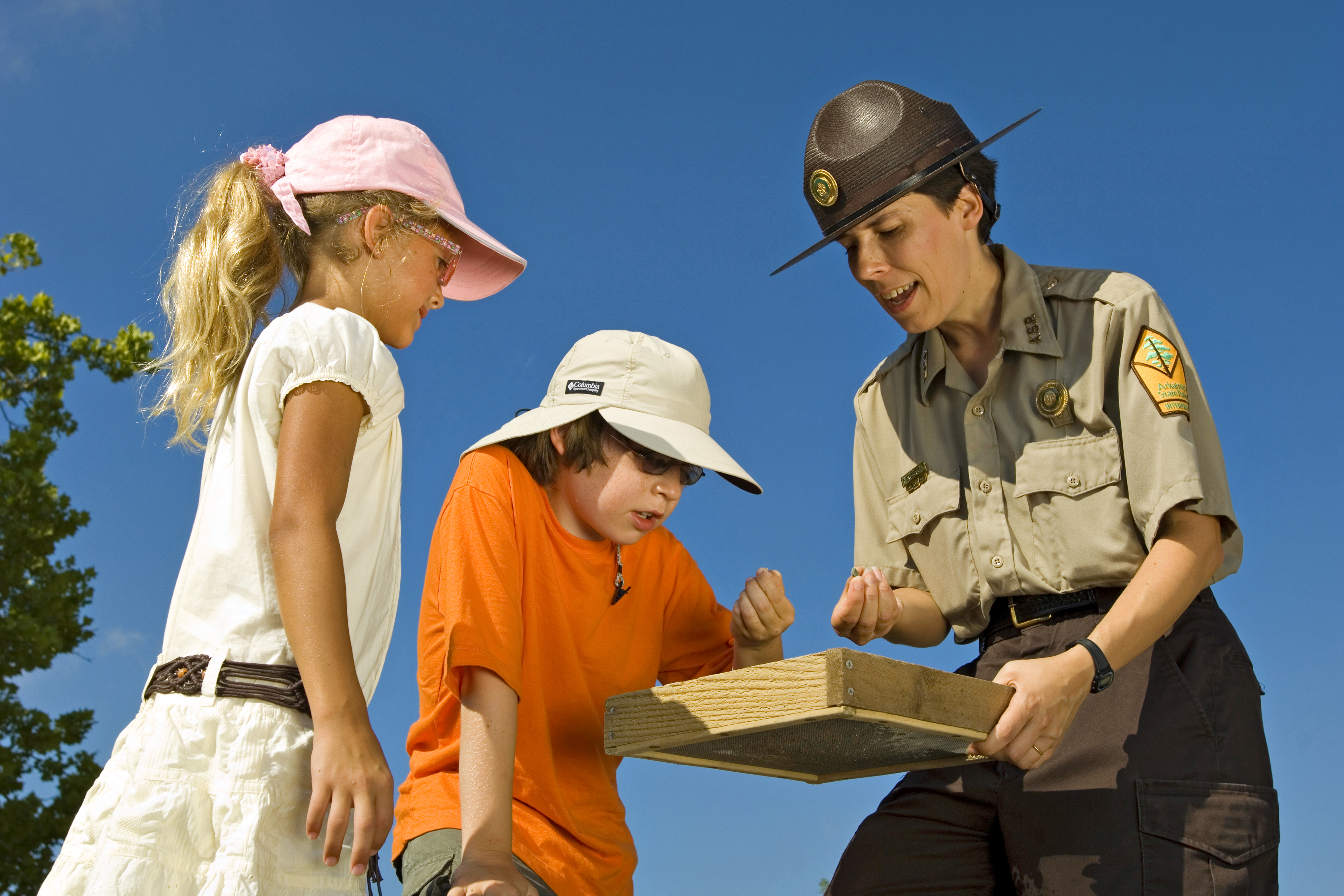 Park interpreter showing children how to search for diamonds at Crater of Diamonds State Parks