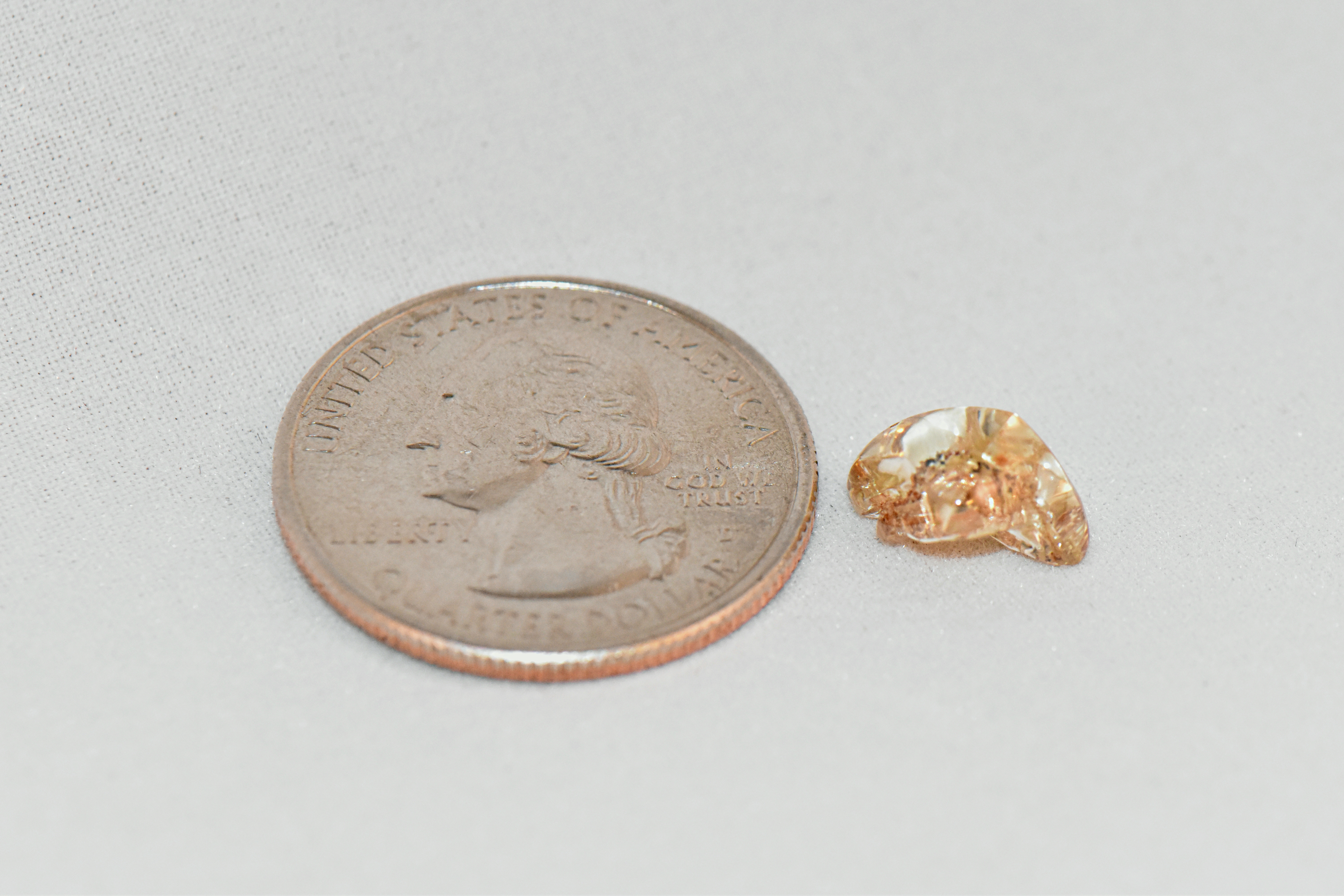 Miranda Hollingshead's 3.72-carat yellow diamond next to a quarter to show scale and size
