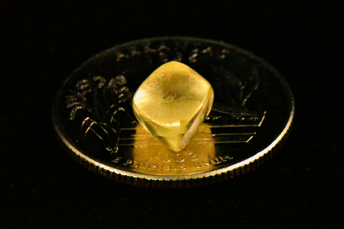 Noreen Wredberg's yellow diamond sitting on a quarter for scale