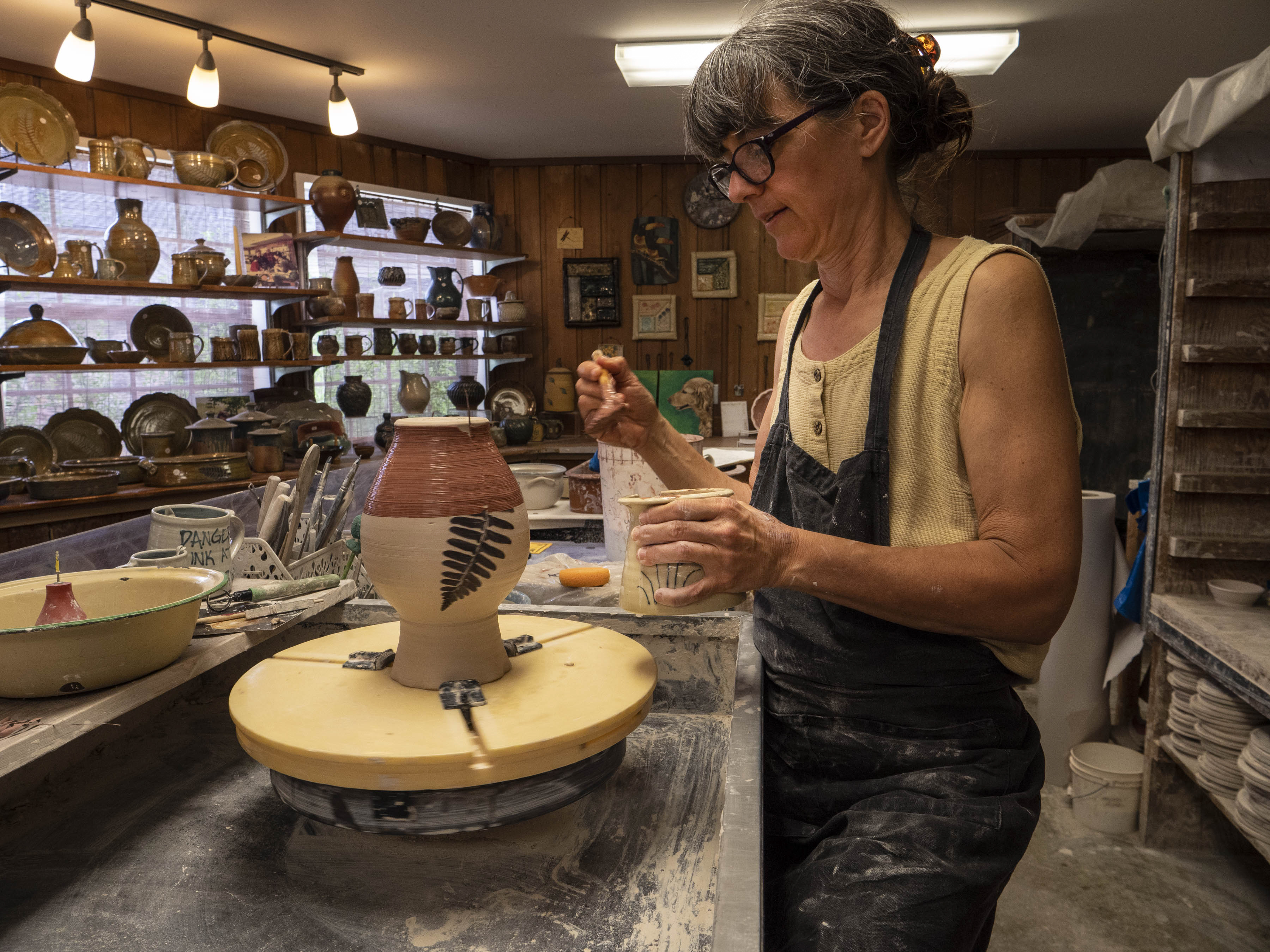 Woman painting pottery at the Ozark Folk Center State Park Craft Village