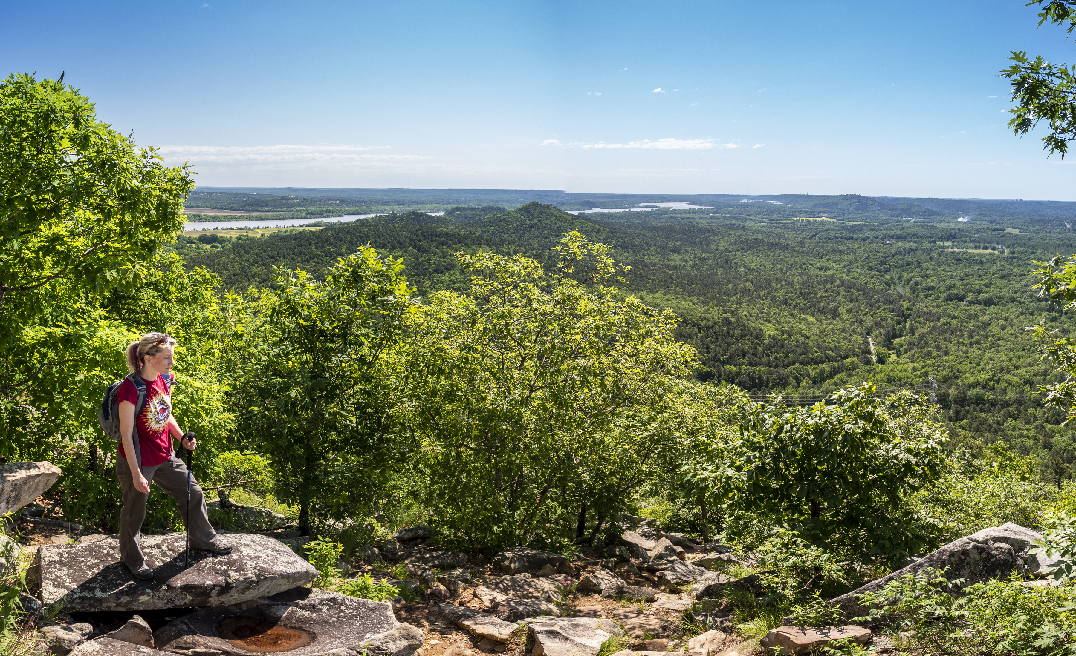 Woman hiking surrounded by trees and rocks on the East Quarry Trail