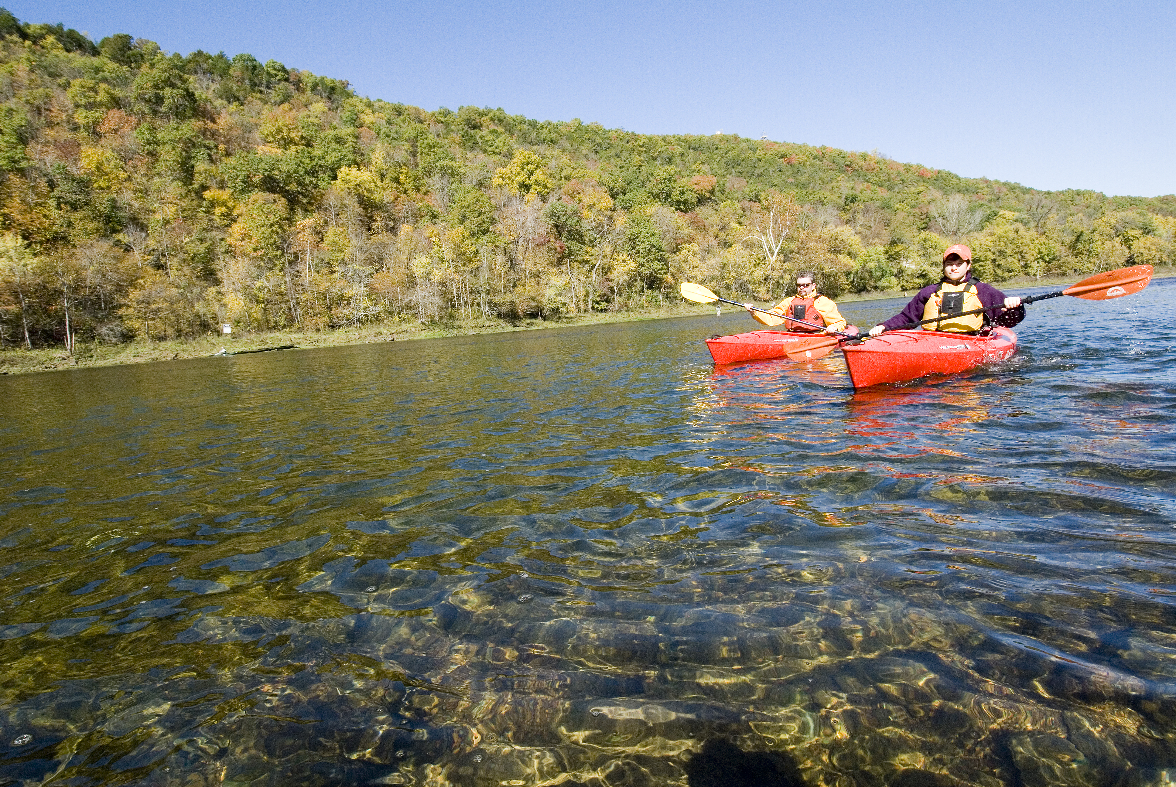 Kayakers paddling on Bull Shoals on a clear spring day