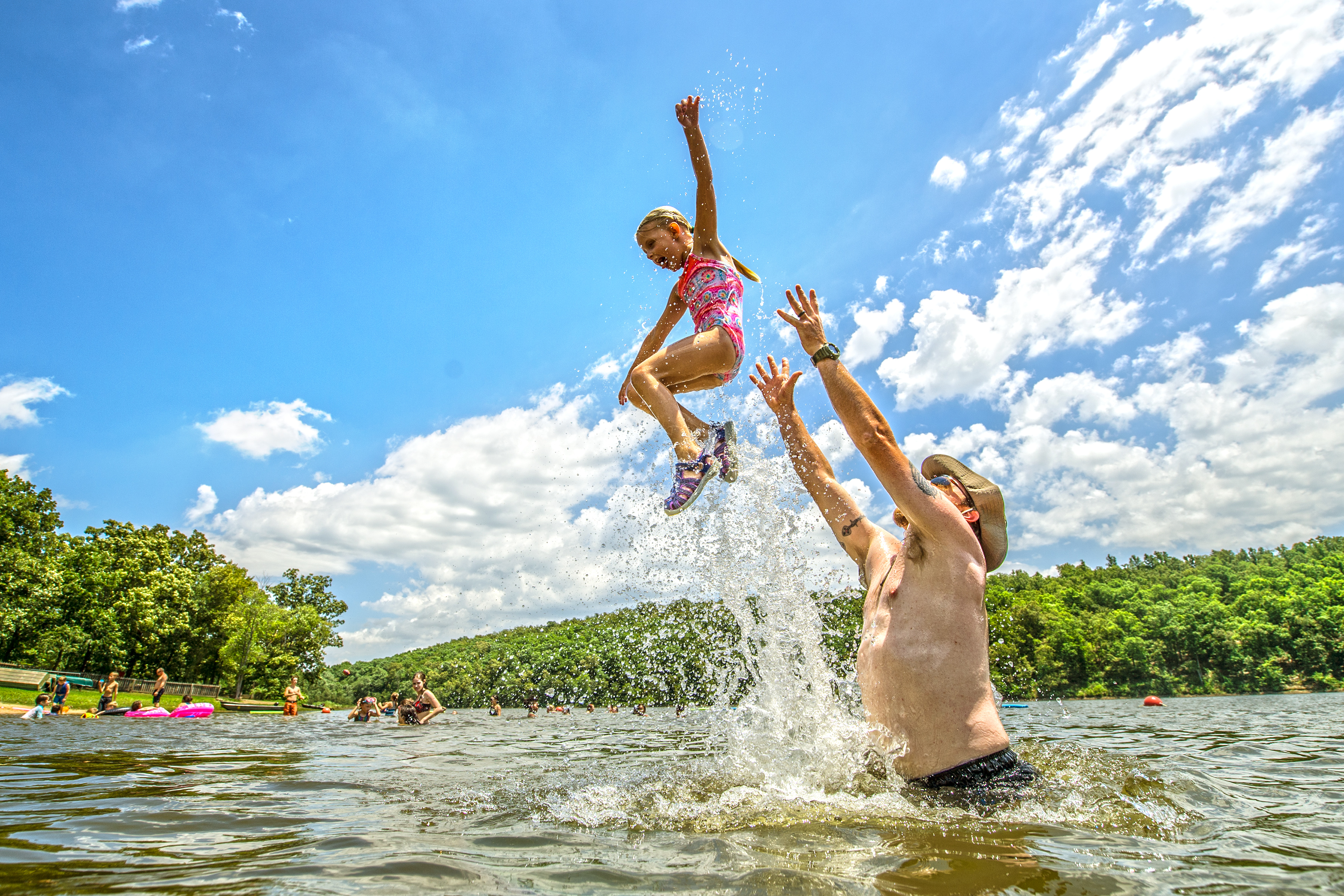 Dad throwing daughter in the air in the lake at Woolly Hollow State Park