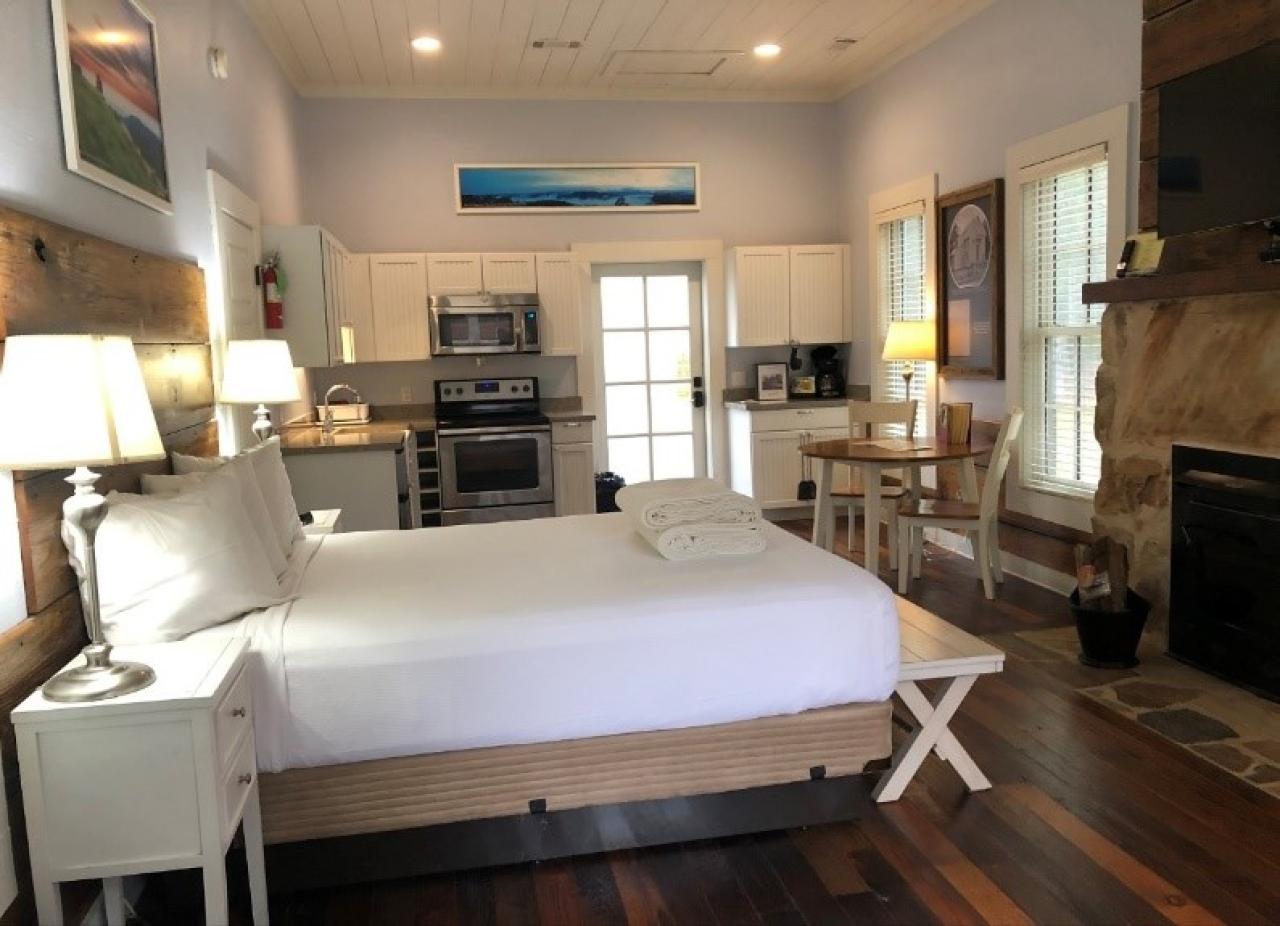 A view of the bedroom area with the kitchen and dining room in the background in Cabin 1 at Mount Nebo State Park