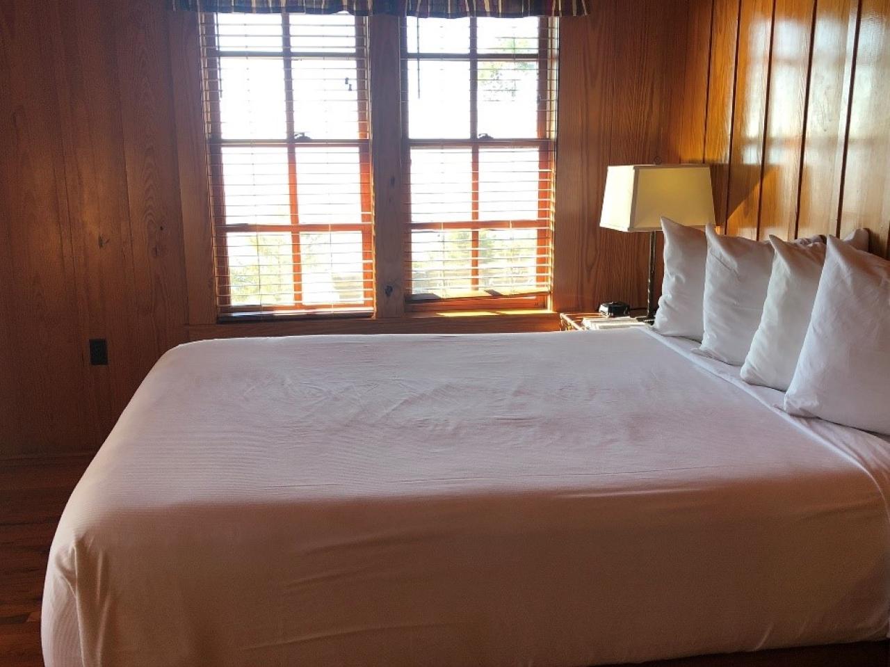 A view of the bedroom in Cabin 2, which includes a bed with a window view