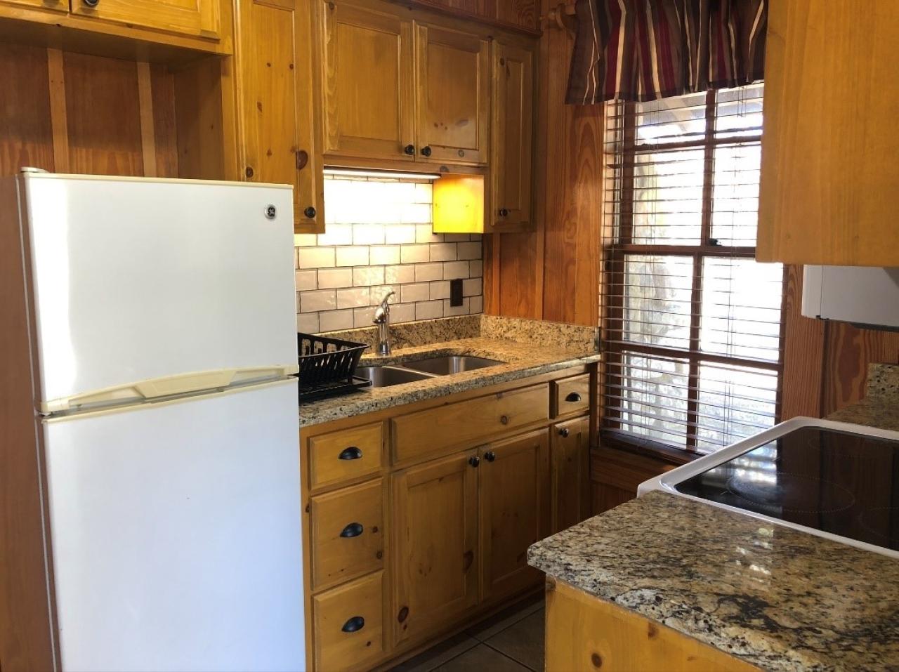 A view of the kitchen in Cabin 2, which includes a full-sized fridge, oven, microwave and sink