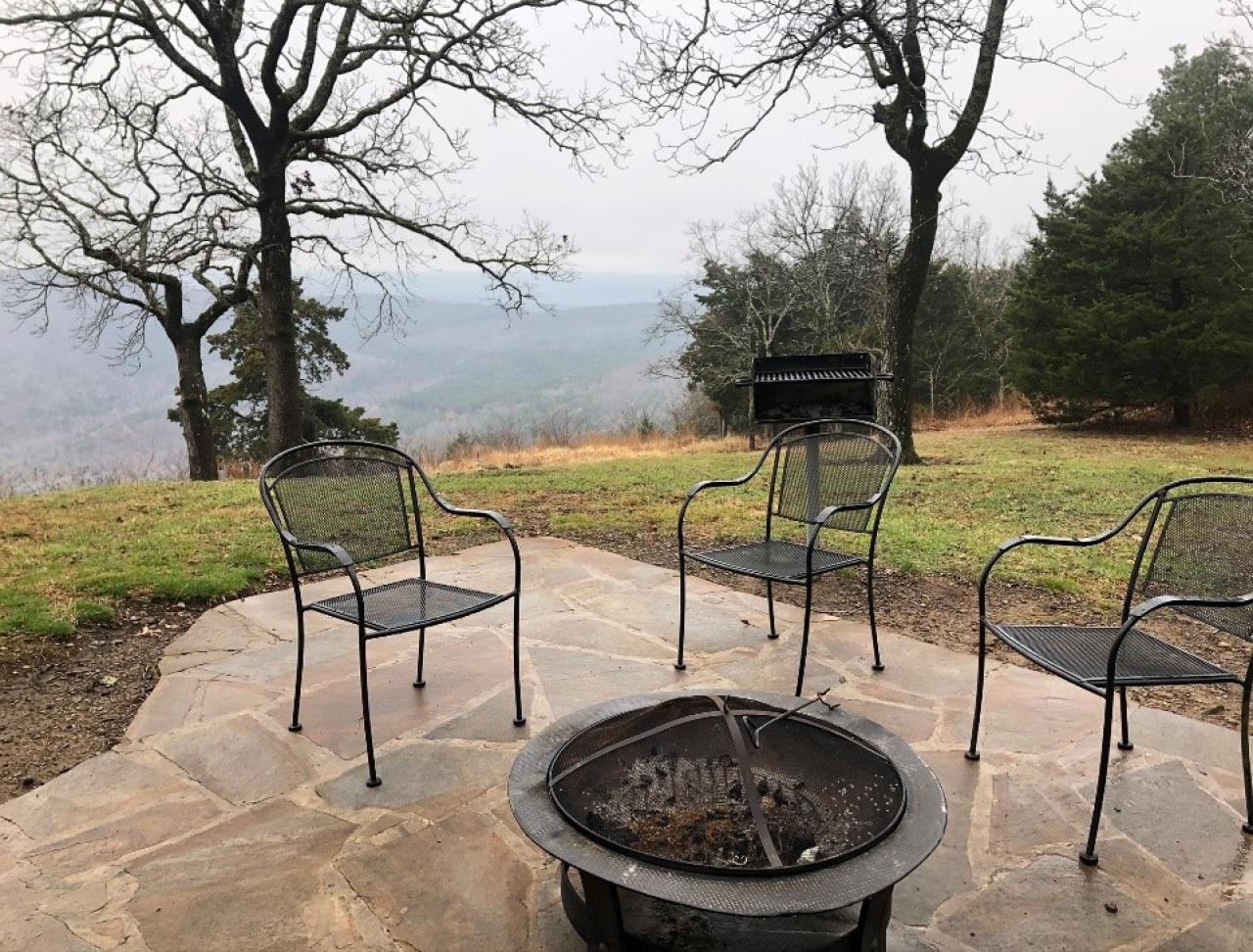 A view of the outdoor seating area, firepit, and outdoor grill with a view at Cabin 5 at Mount Nebo State Park