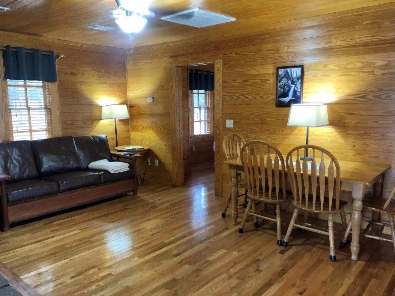 A view of the couch and dining table in the living room/dining room at Cabin 8 at Mount Nebo State Park