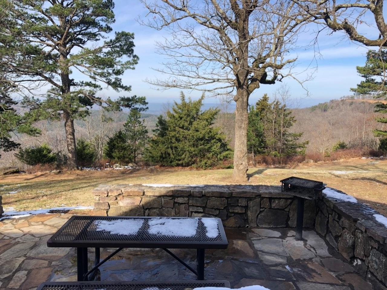 The outdoor seating area, outdoor grill, and view from the back of Cabin 9 at Mount Nebo State Park