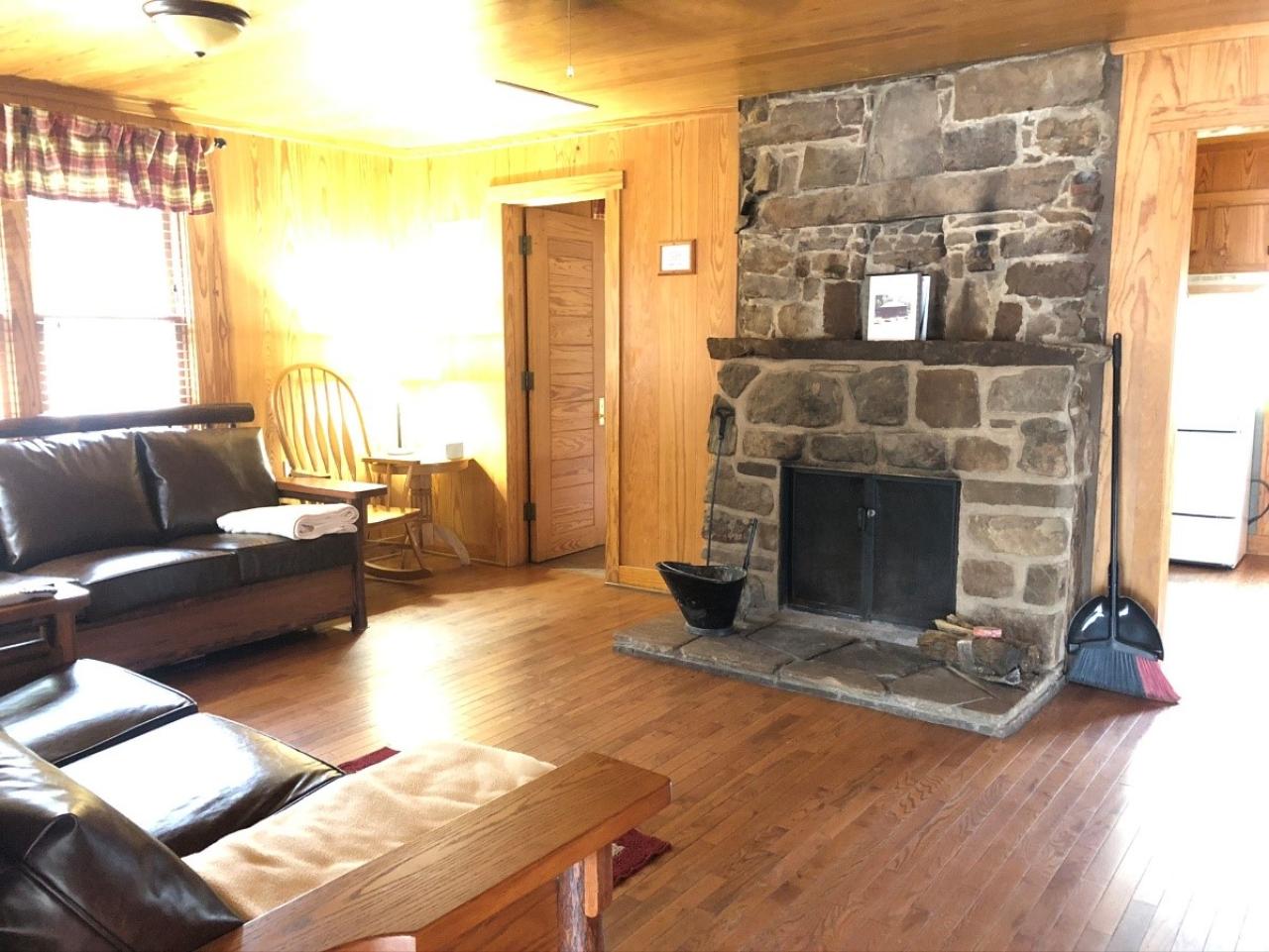 A view of the living room seating area and indoor fireplace at Cabin 12 at Mount Nebo State Park