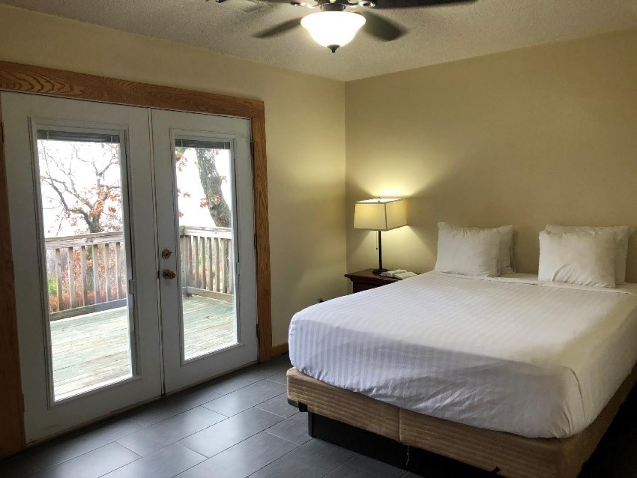 A view of the bedroom with french doors leading to deck at Cabin 11 at Mount Nebo State Park