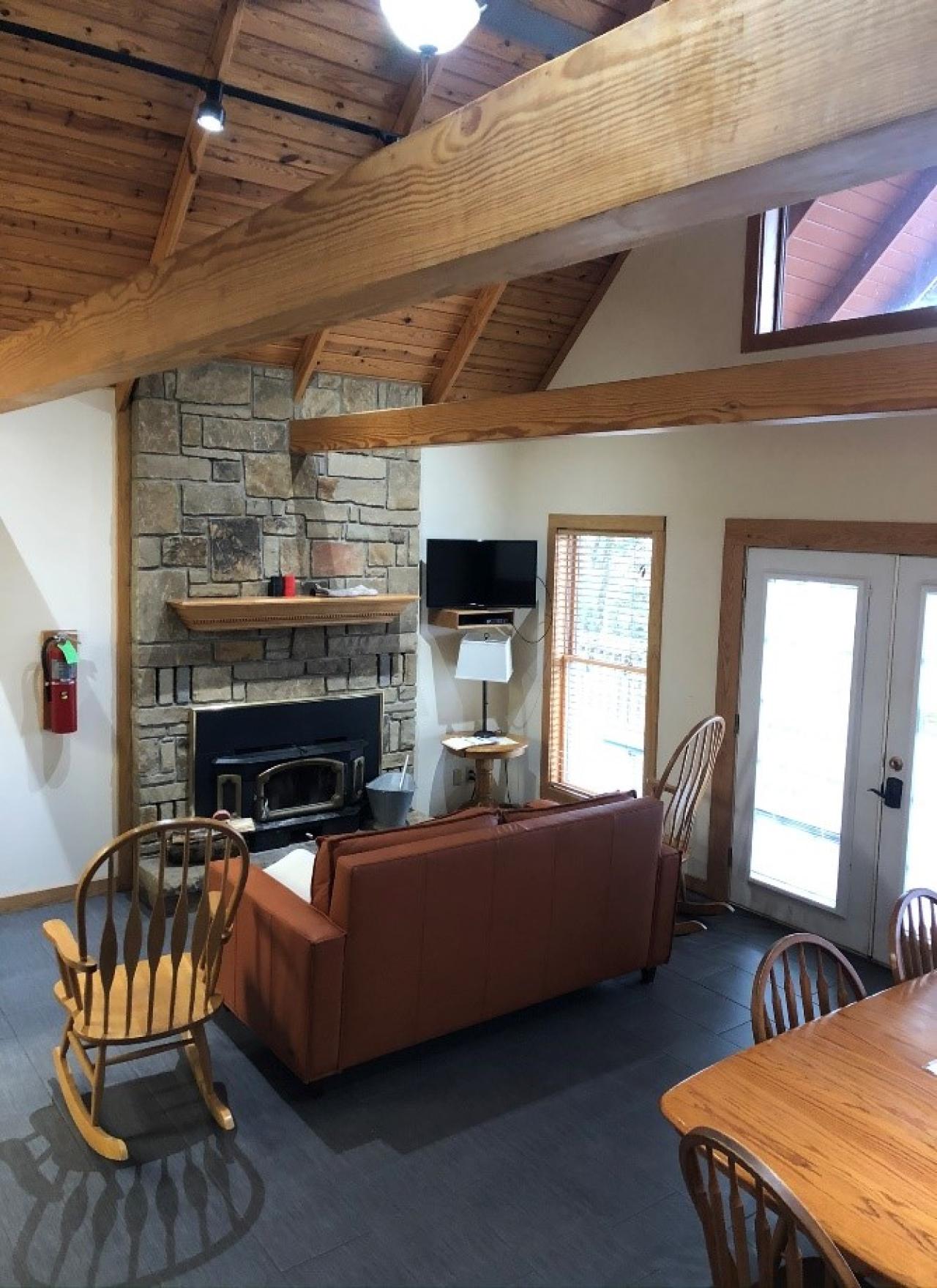 A view of the living room including seating area, indoor fireplace, and dining area at Cabin 11 at Mount Nebo State Park