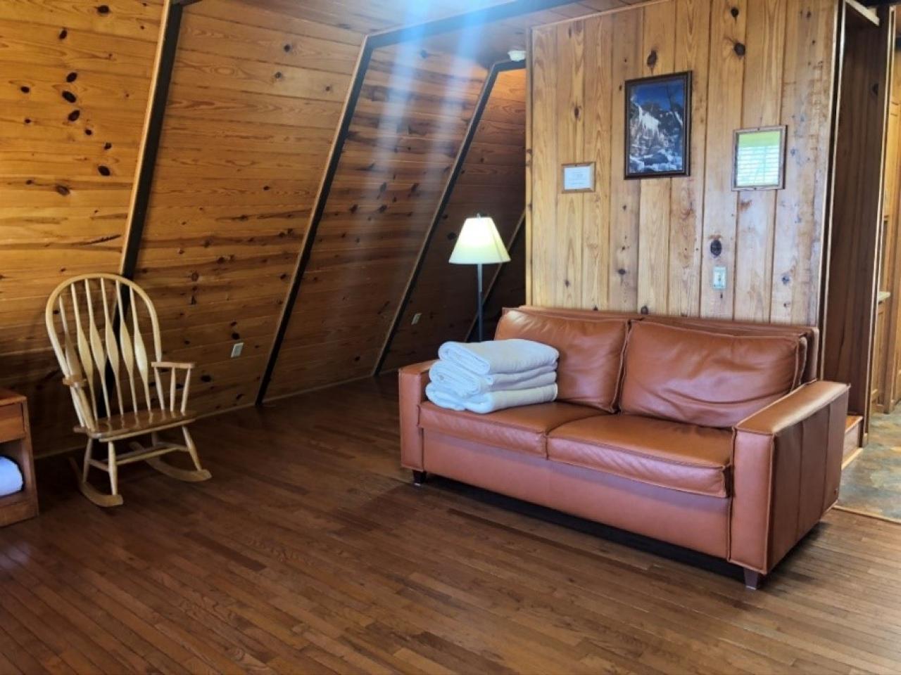 A view of the couch and rocking chair in the living room at Cabin 10 at Mount Nebo State Park