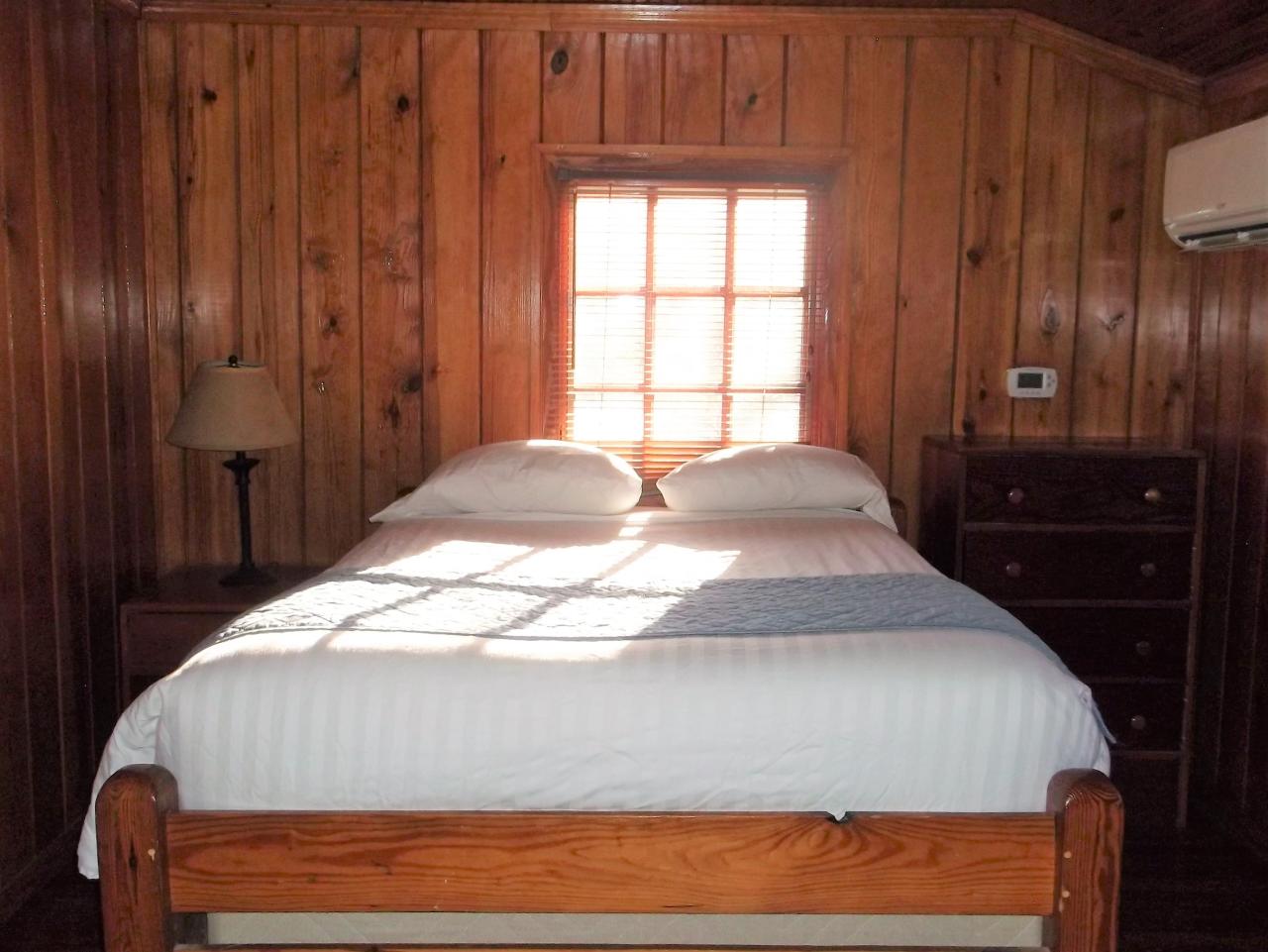A view of one of the bedrooms at cabin 14 a bed, dresser and exterior window