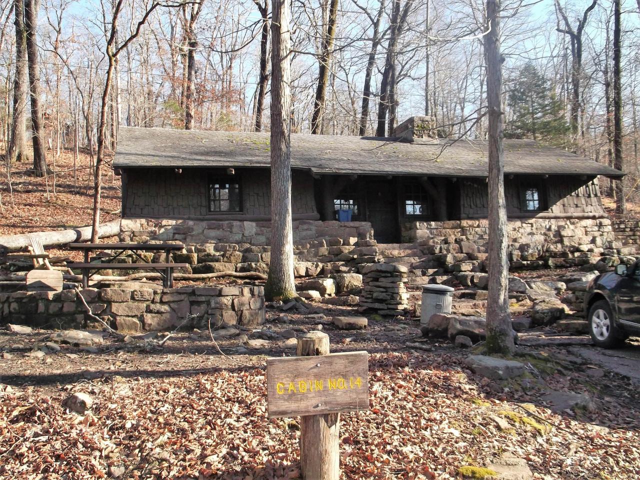 An exterior view of the front entrance for cabin 14 including the stone staircase to the front door and parking spot directly in front of the cabin