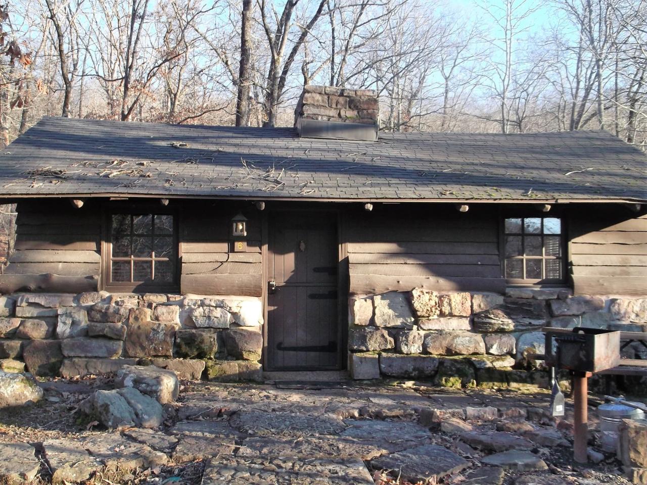 Exterior front entrance view of Cabin 6 including the front door, outdoor grill and outdoor seating area