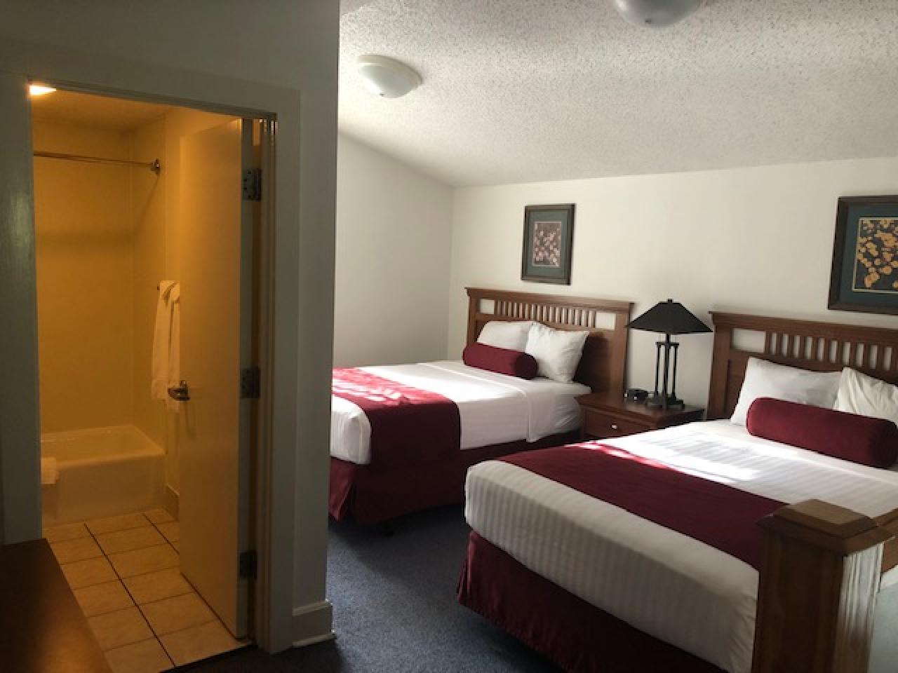 A view of the upstairs loft bedroom at Cabin 1 at Lake Ouachita State Park including a full bathroom and two beds