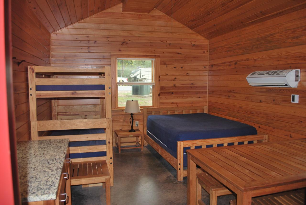 An interior view of Camper Cabin 59 at Lake Ouachita State Park including 3 beds and a dining table