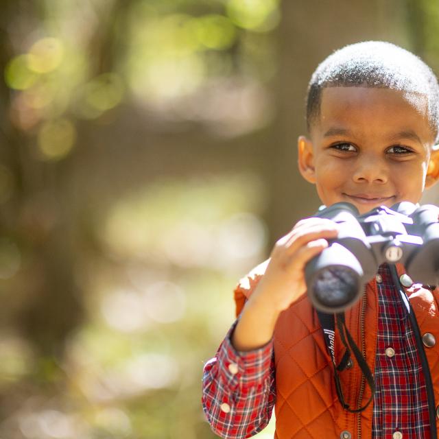 Child looking out binoculars at Logoly State Park