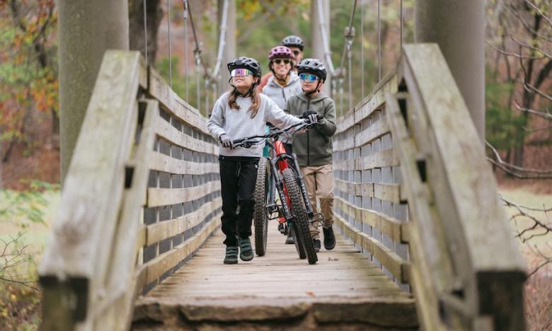 family biking over a bridge with bikes