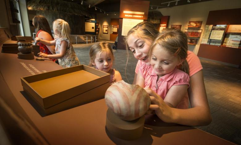 Two girls interacting with a display inside of the Hampson Museum