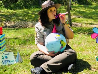 park interpreter holding earth ball with a party streamer