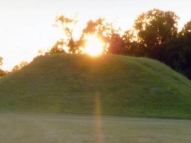 Sun setting over a mound at Plum Bayou Mounds Archeological State Park