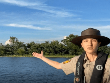 Park interpreter Jenn Menge motioning to purple martins on Lake Ouachita