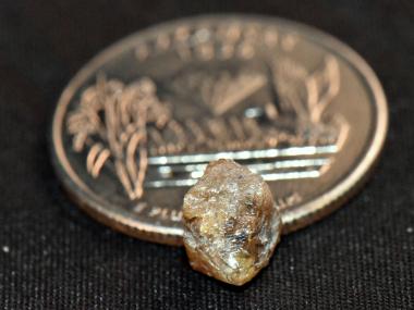 David Anderson's 3.29-carat diamond at Crater of Diamonds State Park next to a quarter for size comparison.