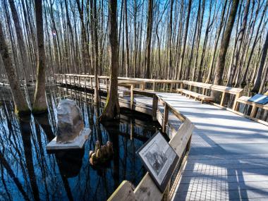 An elevated boardwalk leads to a granite monument at Louisiana Purchase State Park. Arkansas Tourism file photo.