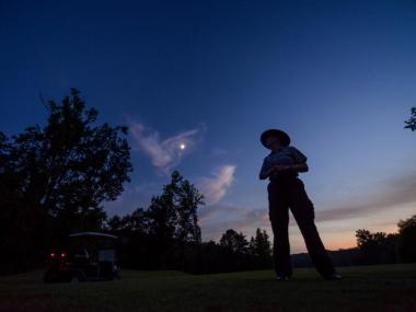 Picture of park interpreter on golf course with night sky