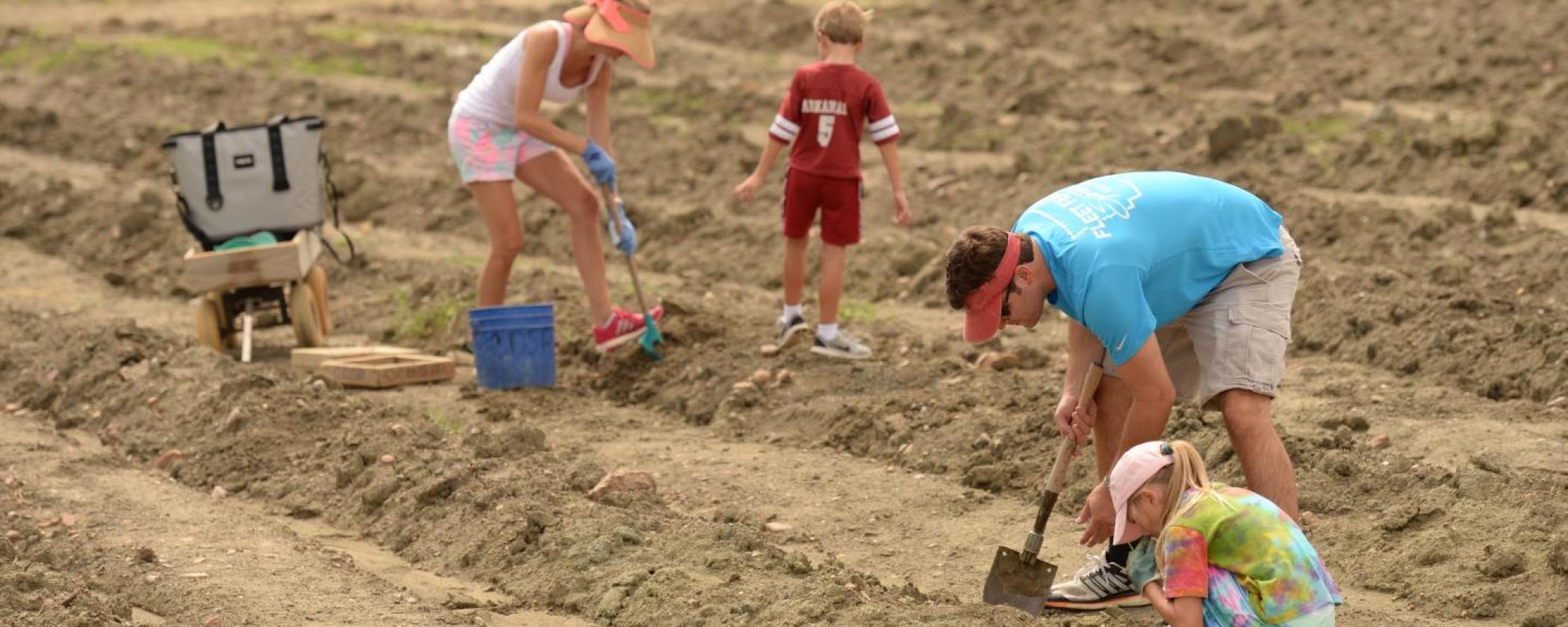 Family searches for diamonds with small shovels at Crater of Diamonds State Park