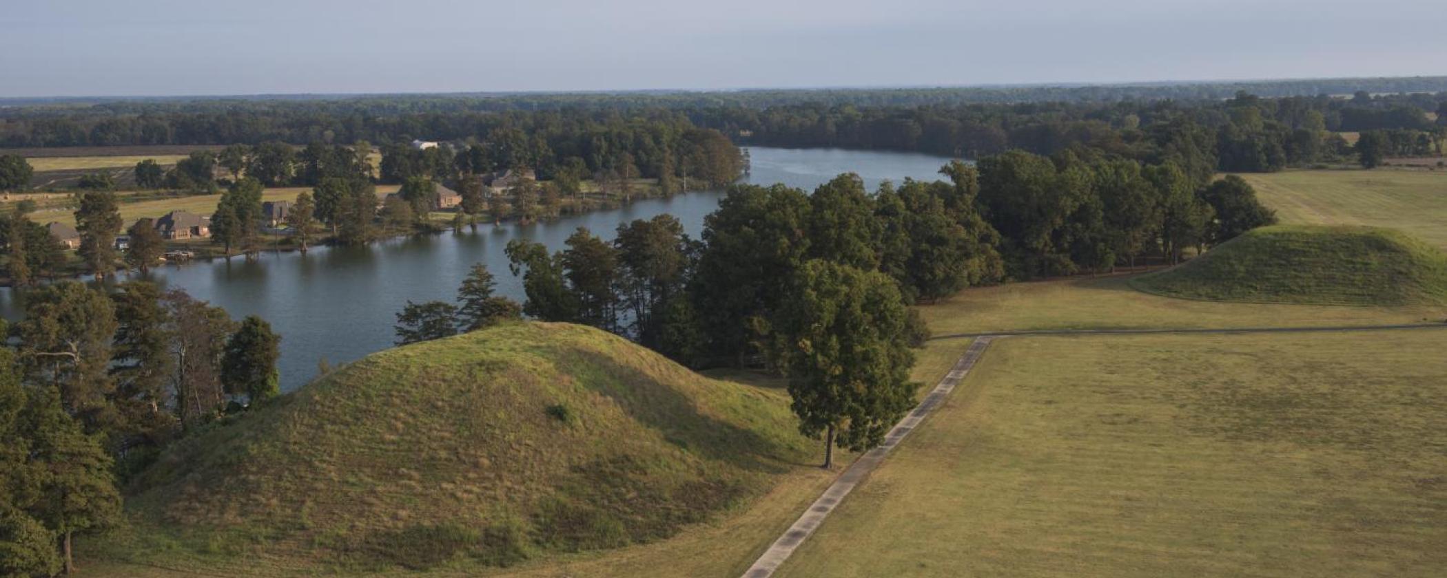 Aerial shot of the mounds next to the lake at Plum Bayou Mounds Archeological State Park