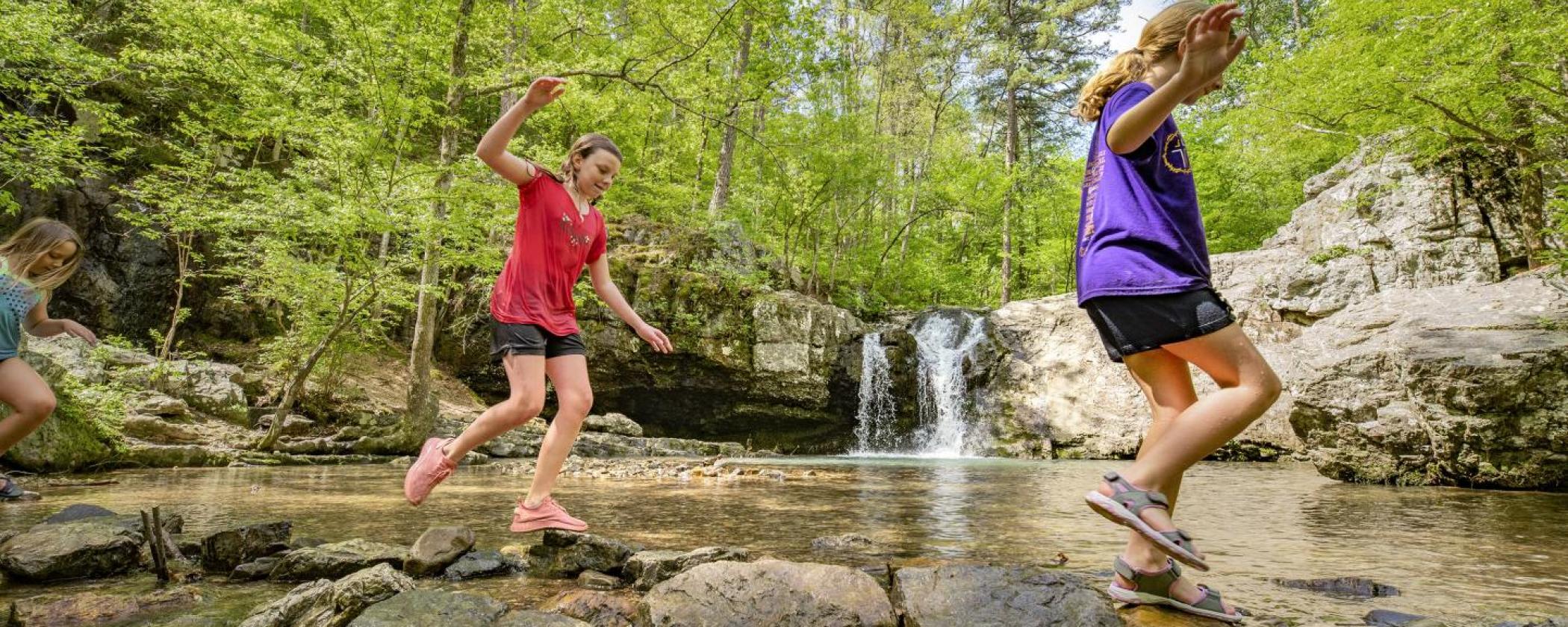 Children playing at the Lake Catherine waterfall on the Falls Branch Trail
