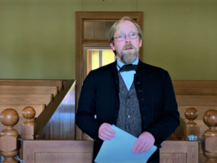Josh Williams dressed in period wear reading the Declaration of Independence
