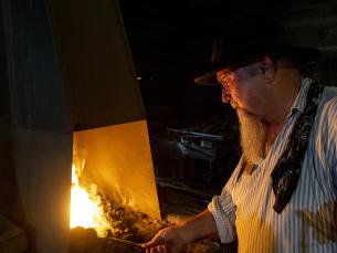 Blacksmith at Historic Washington State Park forging a leaf in the fire
