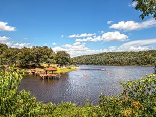 40-acre Lake Bennett surrounded by trees and greenery with a covered dock at Woolly Hollow State Park