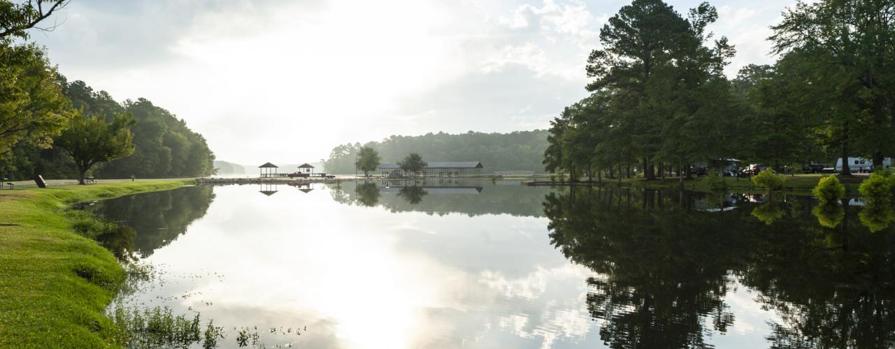 A morning view of White Oak Lake with gazebos and a marina in the distance at White Oak Lake State Park