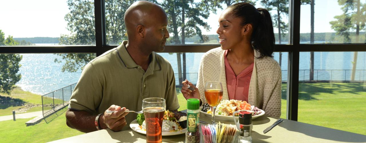Couple dining at the Shoreline Restaurant with a backdrop of views of DeGray Lake