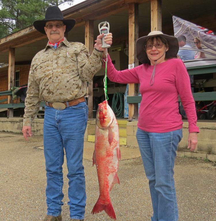 Darlene and Trey Cathey hold up a Silver Carp