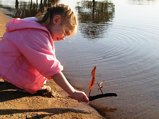 Emily sends her driftwood boat on its maiden voyage.